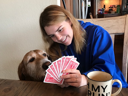 Sarah showing her playing cards to dog Oliver