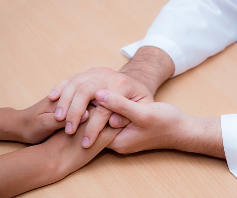 doctor holding a patient's hands in support