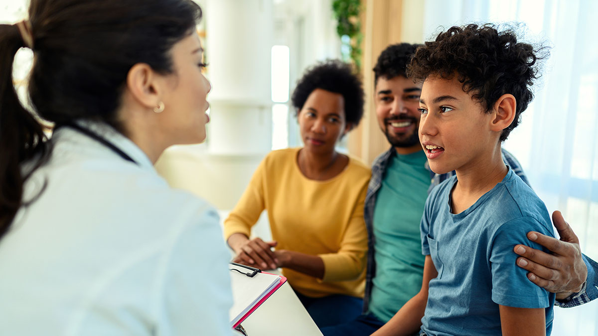 Parents with young son talking with doctor about ADHD treatment options.