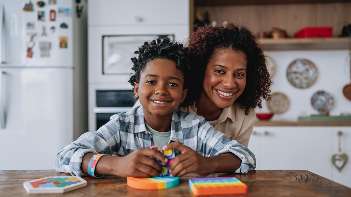 A mother and her son playing at the kitchen table