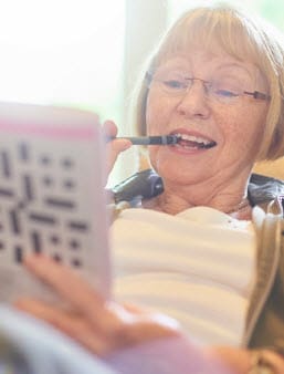 Elderly woman working a crossword puzzle