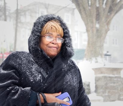 Older woman walking in a snow storm