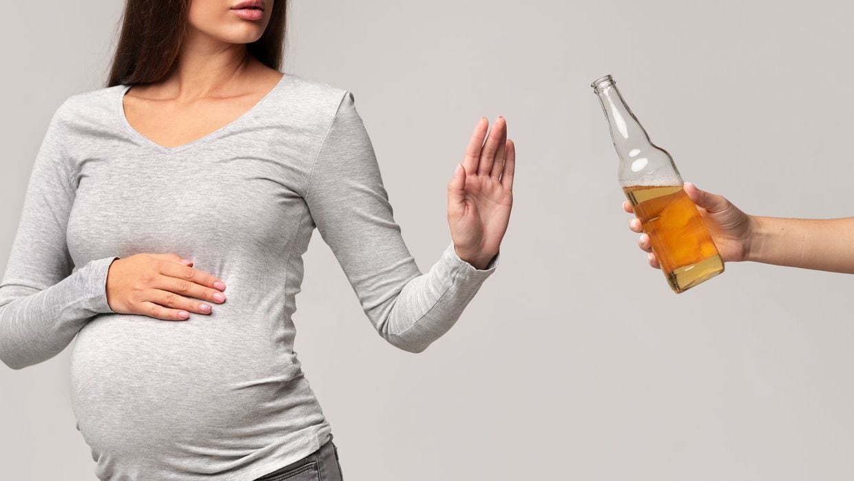 Pregnant woman refusing beer