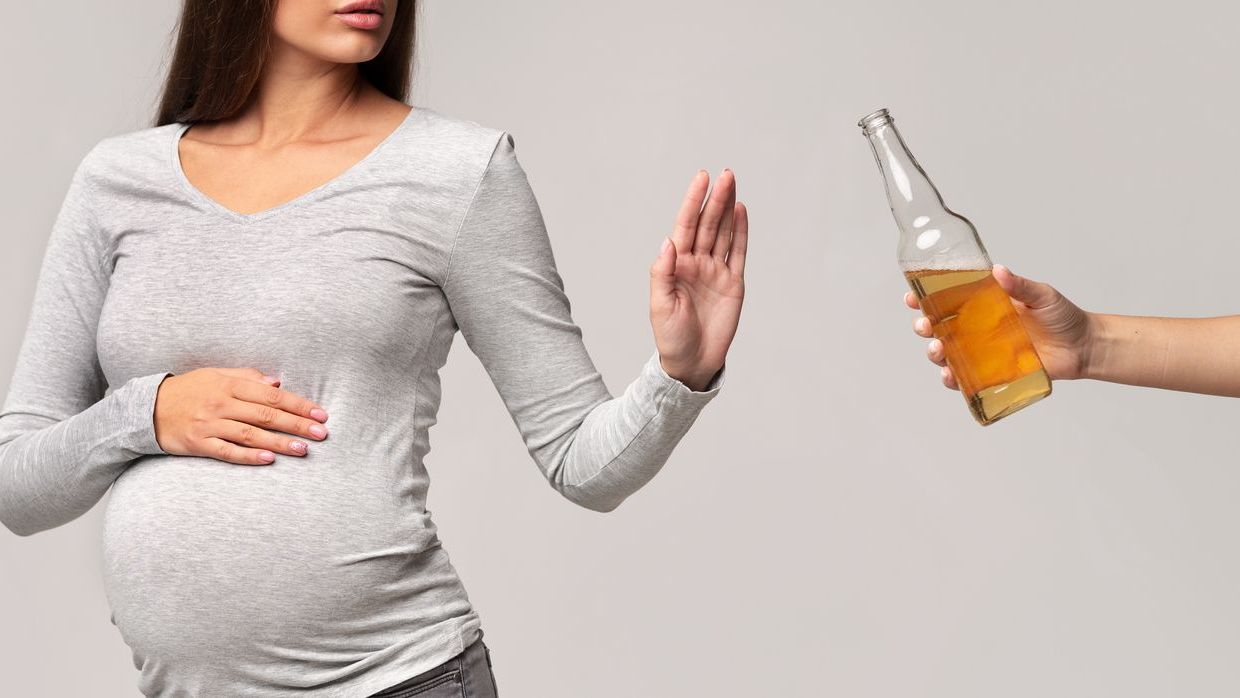 Pregnant woman refusing beer