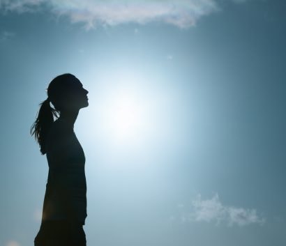 Silhouette of woman looking up at sky