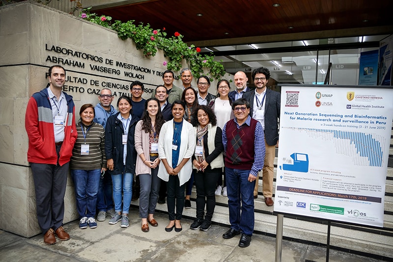 trainers and attendees stand together outside a building with the words Laboratorio de Investigació n de Productos Naturales de la Amazonia
