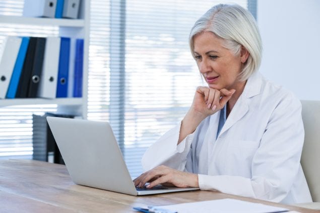 Thoughtful female doctor working on her laptop