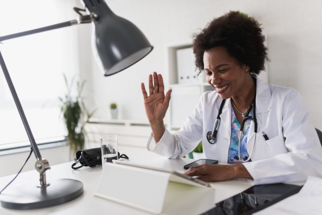 Physician waving to patient in virtual appointment