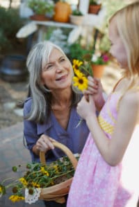 grandmother and granddaughter holding flowers in garden