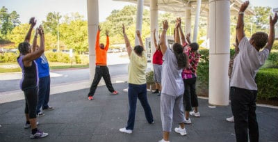 group of adults stretching outside