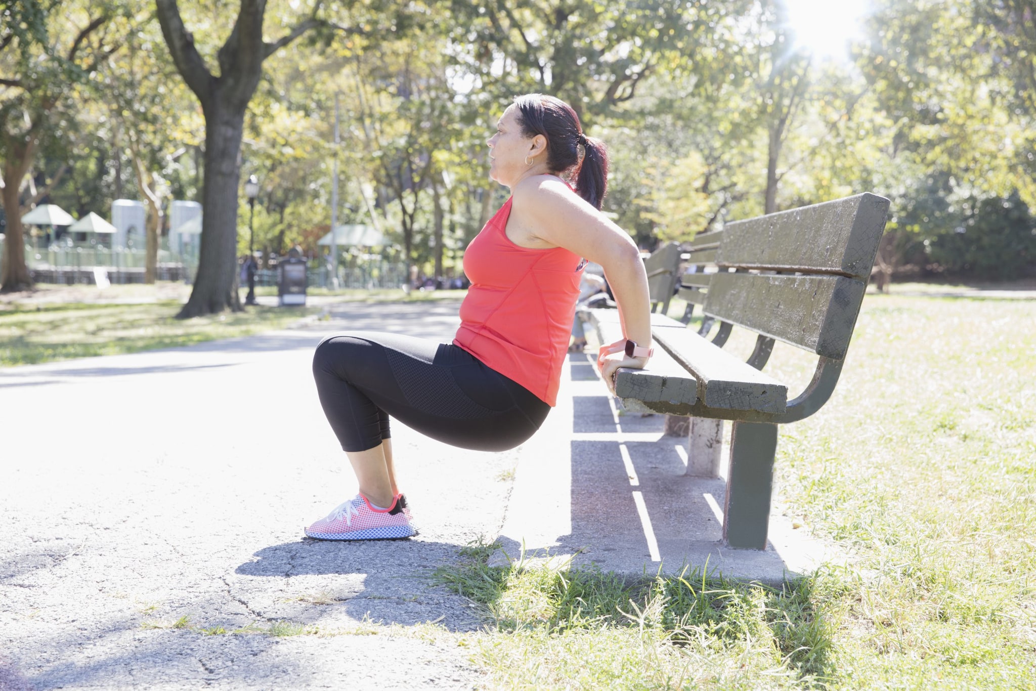 woman exercising on park bench
