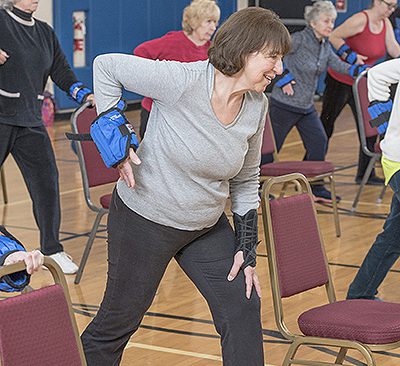 Arthritis Partner: Women stretching alongside folding chairs