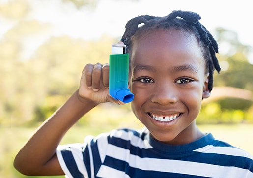 CDC EXHALE Young child smiling holding up an inhaler