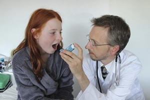 Doctor gives patient a dose from an inhaler