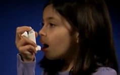 young girl using an asthma inhaler