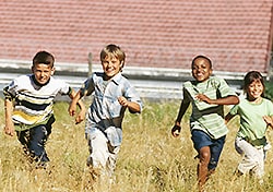 kids running through a field of tall grass