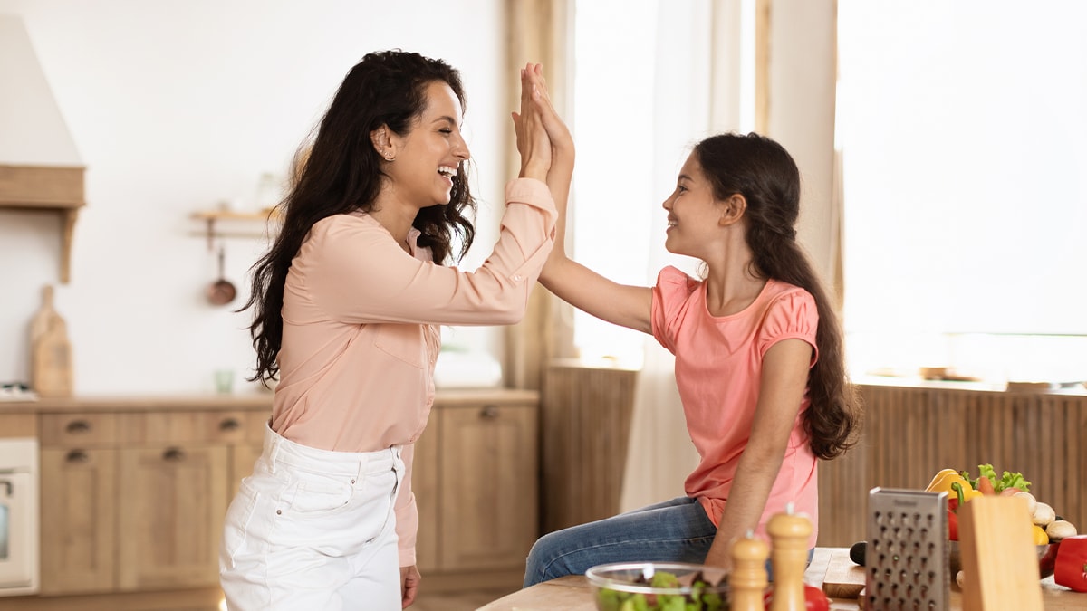 Mother high-fiving young daughter