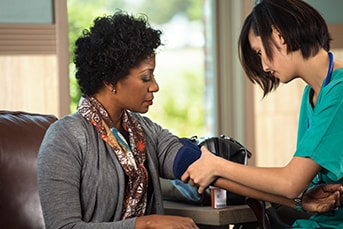 Nurse taking woman's blood pressure.