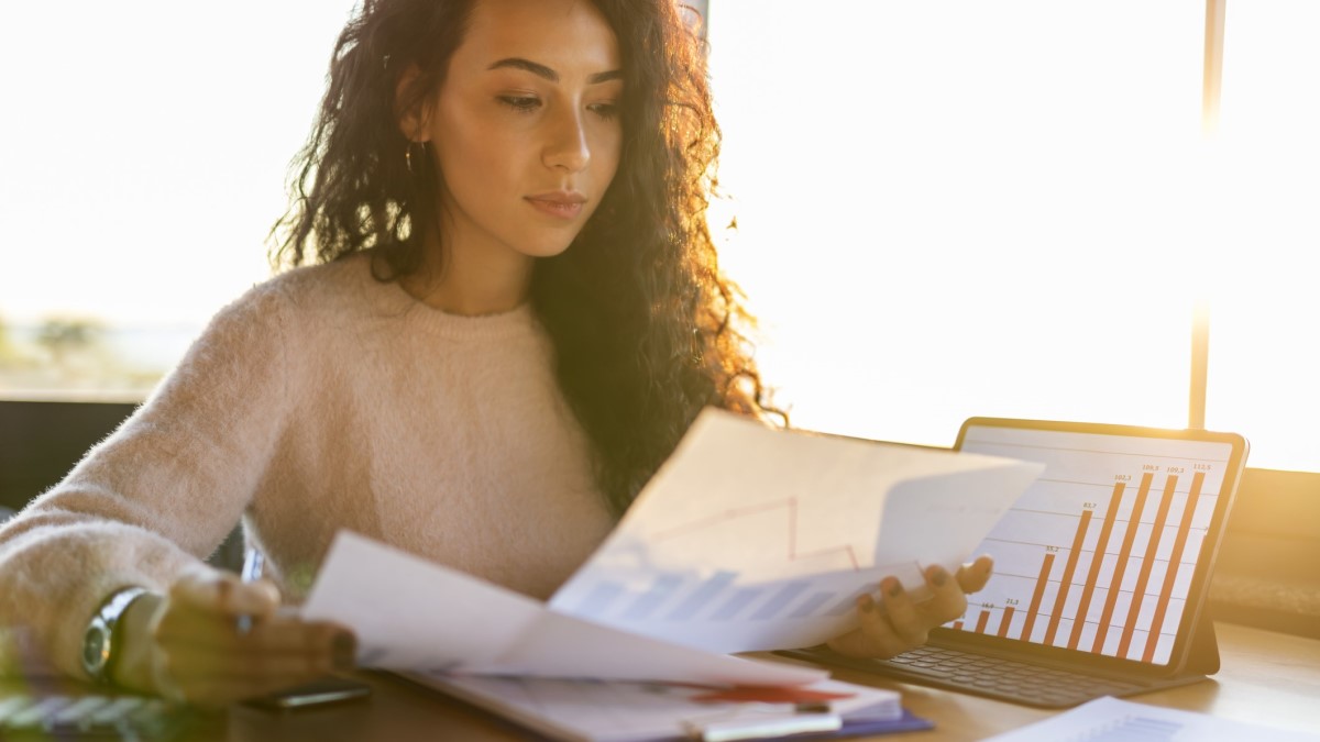 Photo of a woman looking at charts and graphs