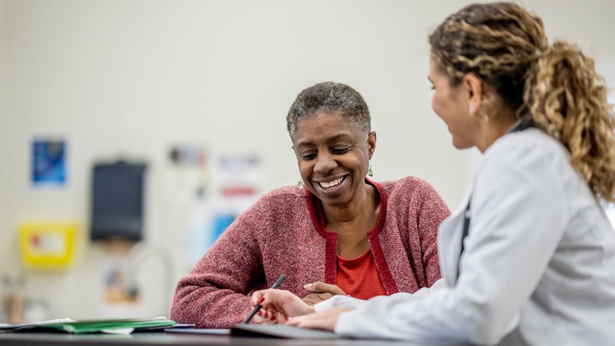 A senior African American woman talks to her doctor