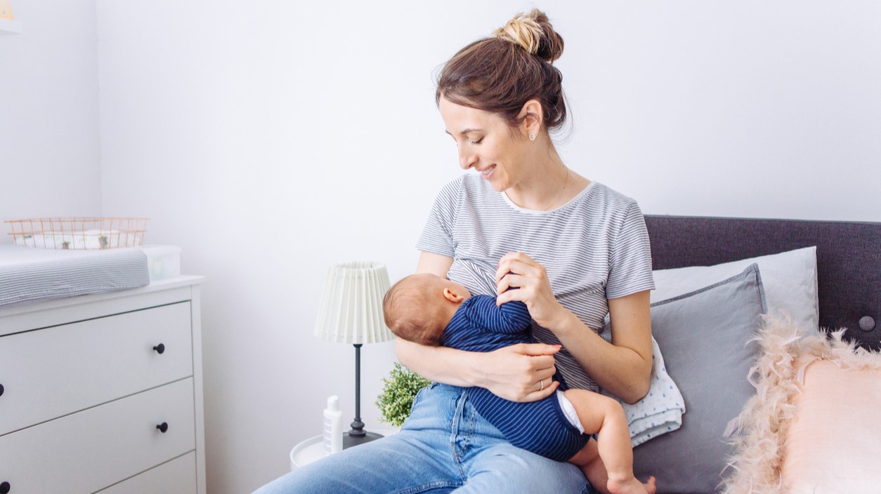 Mother breastfeeding baby in bedroom