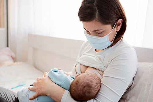 Breastfeeding mother wearing a mask