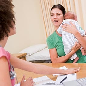 A mother with infant consulting their healthcare professional