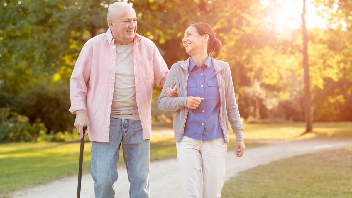 Photo of an elderly man and woman walking outdoors