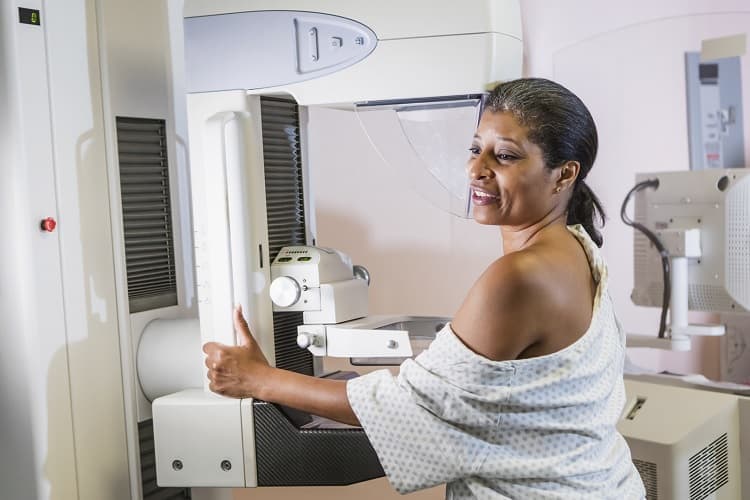 Foto de una mujer que se hace una mamografía.