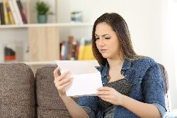 Photo of a confused woman reading a letter