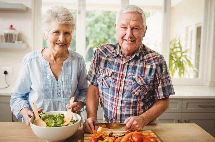 Photo of a man and a woman making a salad