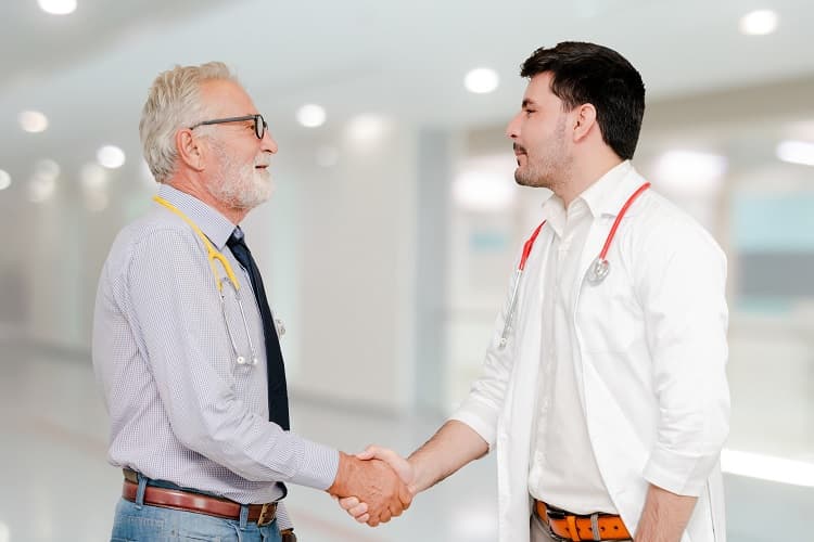 Photo of a doctor and an administrator shaking hands