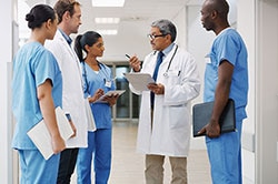 Photo of a group of doctors and clinic staff members having a discussion in a hospital