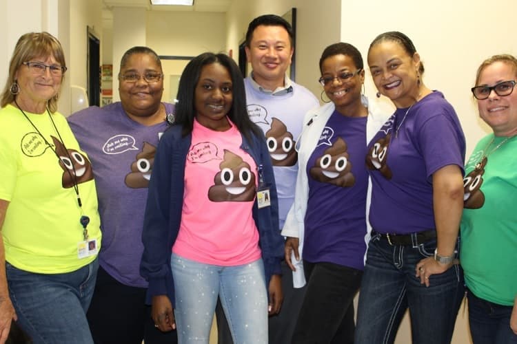 Photo of staff at the St. Petersburg medical home wearing humorous T-shirts to promote colorectal cancer screening with a FIT kit.