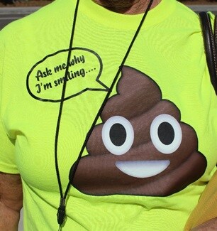 Closeup photo of a T-shirt to promote colorectal cancer screening. It shows a poop emoji saying, Ask me why I'm smiling.