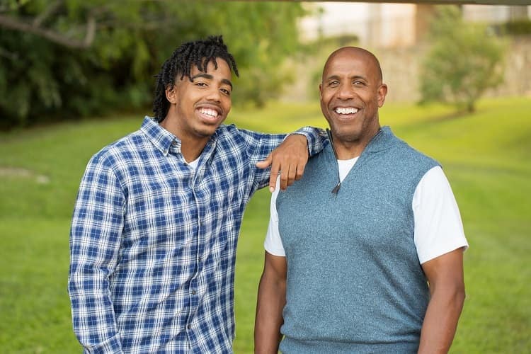 Foto de un padre afroamericano y su hijo adulto