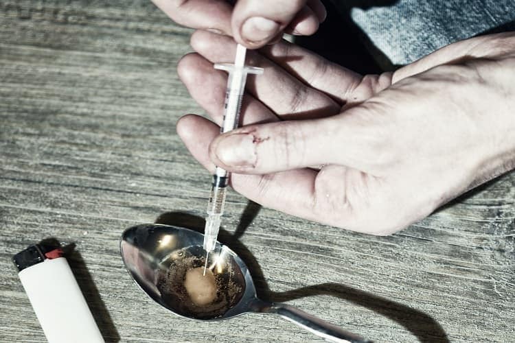 Foto de una persona preparando una inyección de heroina