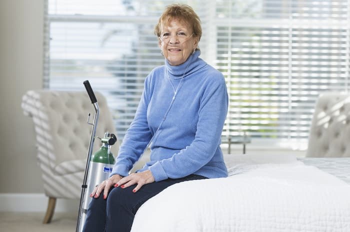 Photo of a woman with a portable oxygen tank