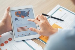 Photo of a woman accessing a map-based application on her tablet.