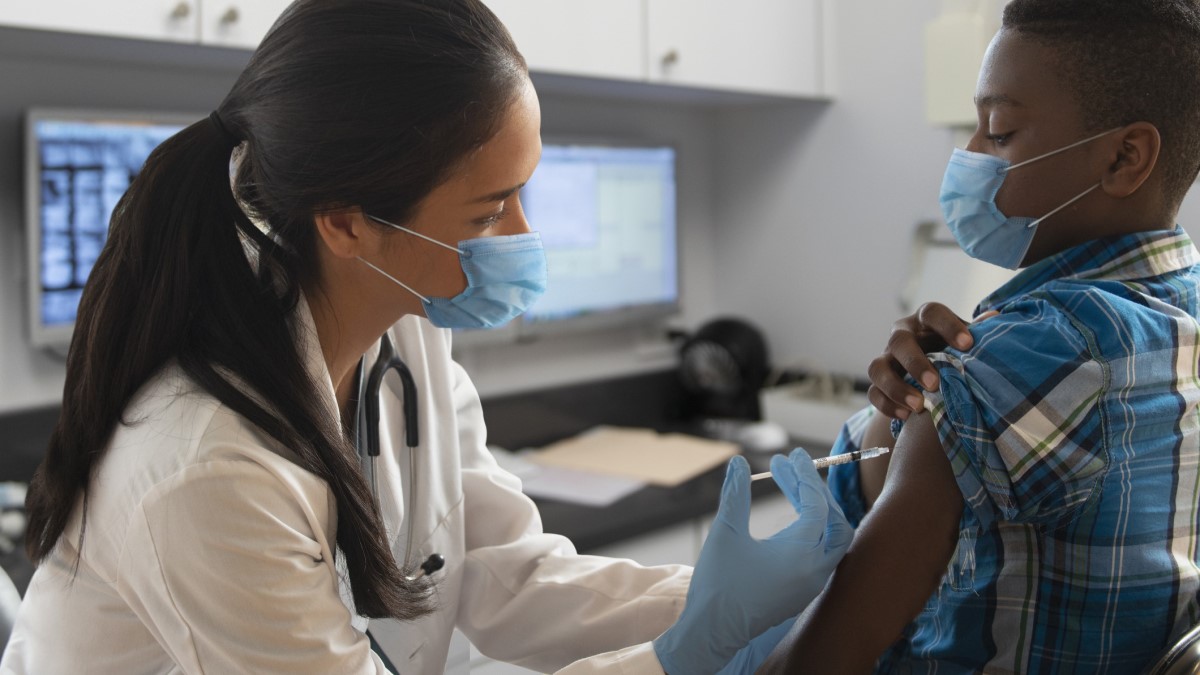 Foto de una médica aplicando una vacuna a un niño