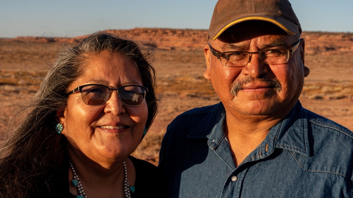 un esposo y una esposa nativos americanos cerca de su casa en Monument Valley, Utah.
