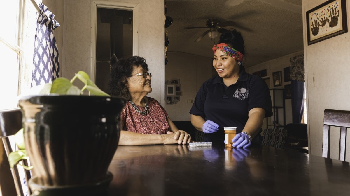 Una trabajadora de salud comunitario ayuda a una mujer navajo con sus medicamentos