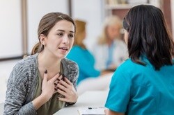 Photo of a concerned young female patient talking with a nurse