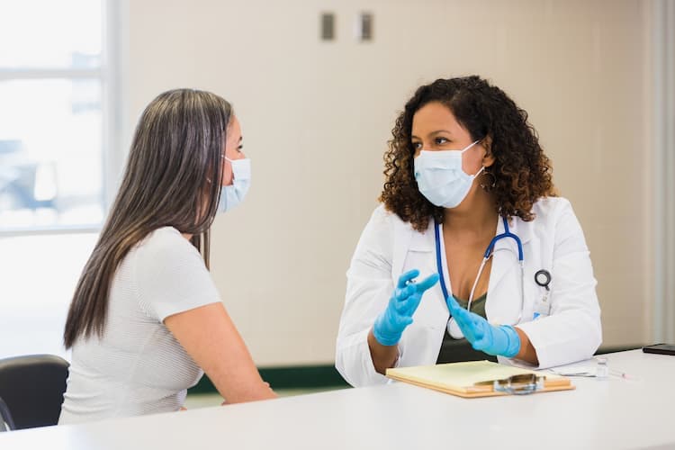 Photo of a concerned young female patient talking with a nurse