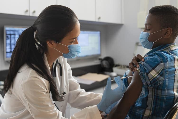 Photo of a doctor giving an HPV vaccine to a boy.