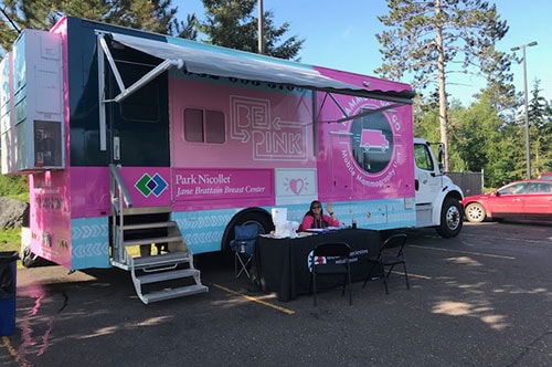 Photo of a health care worker in front of a Park Nicollet Mobile Mammography Unit