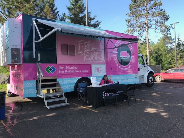 Photo of a health care worker in front of a Park Nicollet Mobile Mammography Unit