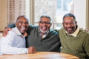 Photo of three men sitting in a table together.