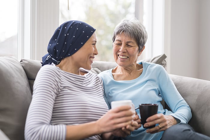 Foto de un paciente de cáncer y su madre tomando café
