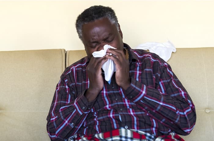 Photo of a man blowing his nose